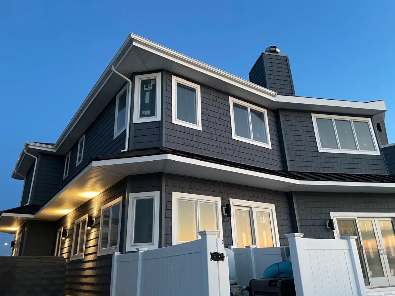Two-story New Jersey home with new white seamless gutters installed by Haus Prime