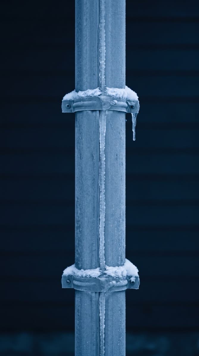 Nieve y hielo acumulados en el borde del techo y las canaletas de una casa en Nueva Jersey en invierno